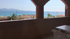 A balcony with a view of the sea, a white table, and a chair. - Le California Motel (Vico)