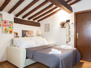 Une chambre à coucher avec un lit, une table de chevet, une lampe, un miroir et une porte.