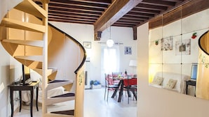 Una escalera en espiral que conduce a un comedor con una mesa dispuesta para dos personas.