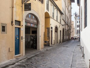 A narrow street with a building featuring a garage entrance.