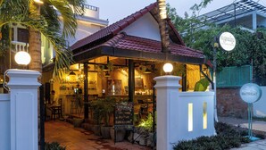 A restaurant with a red-tiled roof, outdoor seating, and a signboard listing food specials. -  River Retreat Boutique Hotel (Siem Reap)