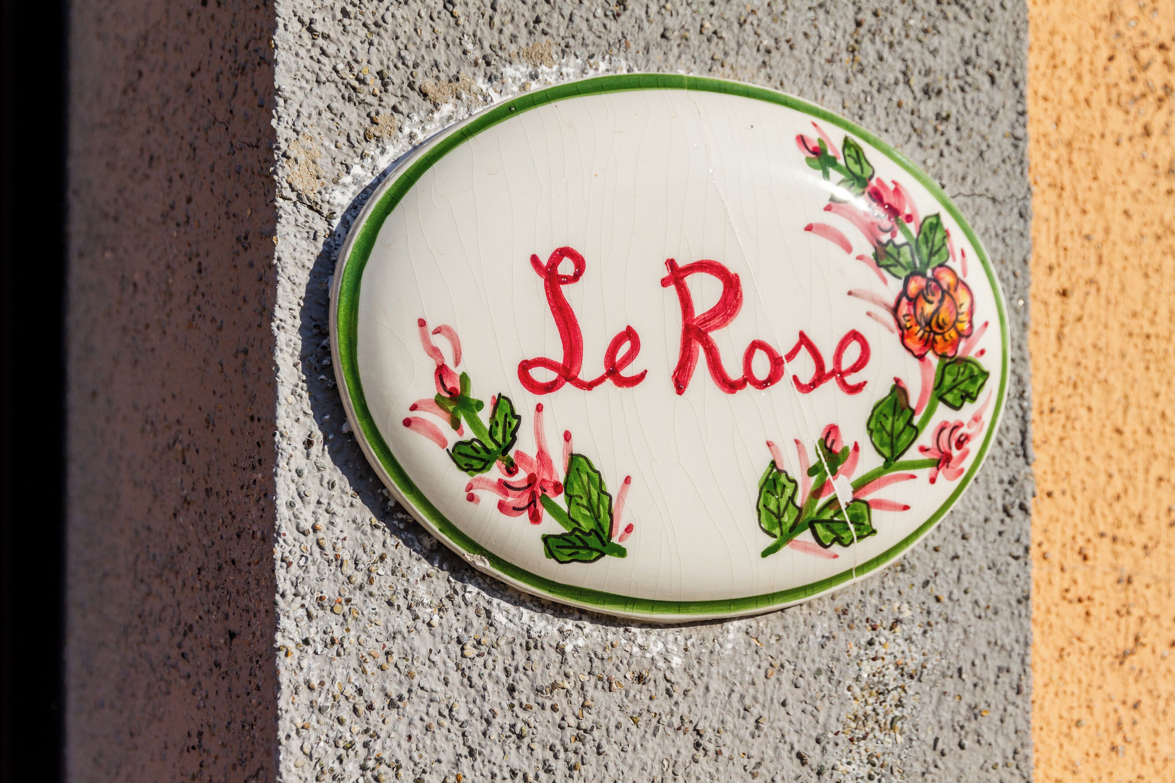 Un plato de cerámica con la inscripción 'Le Rose' y motivos florales.