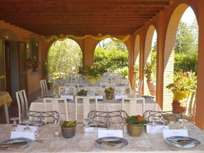 Un área de comedor al aire libre con varias mesas, sillas y tarjetas con nombres.