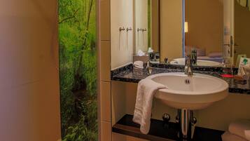 A modern bathroom with a shower, sink, and mirror.
