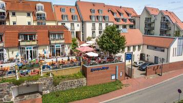 A hotel with multiple balconies, outdoor seating areas, and a brick facade.