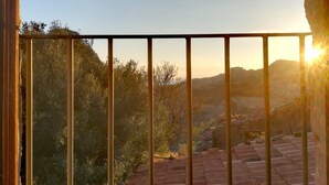 A balcony with a view of a hilly landscape during sunset. - Case Rurali Pentedattilo (Melito di Porto Salvo)