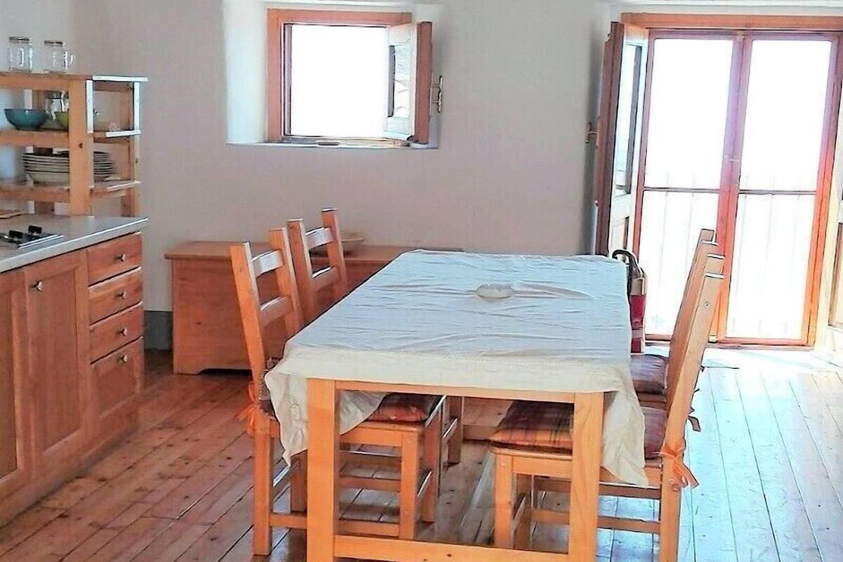 Una mesa de comedor de madera con sillas, un armario de madera y una ventana con vistas.