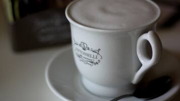 A white cup with "CANTONELLI" text and a spoon on a saucer.