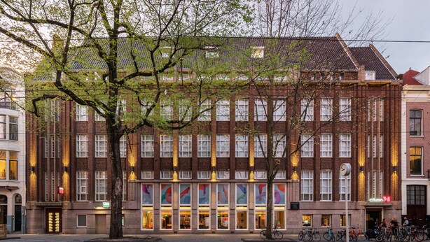 A multi-story building with a brick facade, large windows, and a tree in front. - citizenM Amstel Amsterdam (Amsterdam)