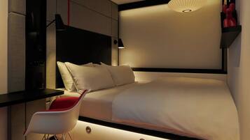 A modern bedroom with a bed, bedside tables, a chair, and a wall-mounted lamp.