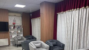A modern living room with grey sofas, a coffee table, and a bookshelf. - Azizoglu Malkoc Hotel (Diyarbakir)