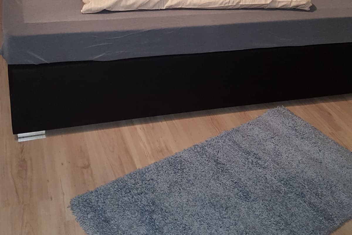 Ein Bett mit einer Matratze, Kissen und einer zusammengelegten Decke.