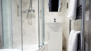 A modern bathroom with a glass-enclosed shower, a white sink, and a toilet. - The Rose & Crown Free House (Clacton-on-Sea)