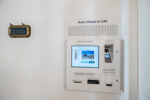 Quiosco de autoservicio disponible las 24 horas con pantalla táctil, ranura para tarjeta de crédito y número de asistencia telefónica.