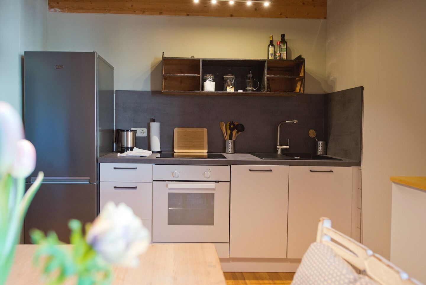 Une cuisine moderne équipée d’un réfrigérateur, d’un four et d’un plan de travail en bois.