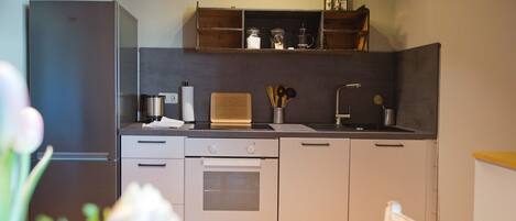 Une cuisine moderne équipée d’un réfrigérateur, d’un four et d’un plan de travail en bois.
