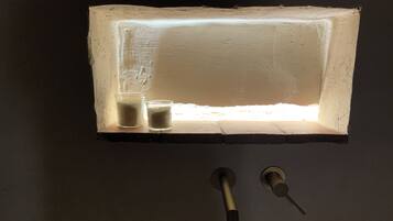 A rectangular light fixture with a frosted glass cover, two small glass containers, and a keyhole below.