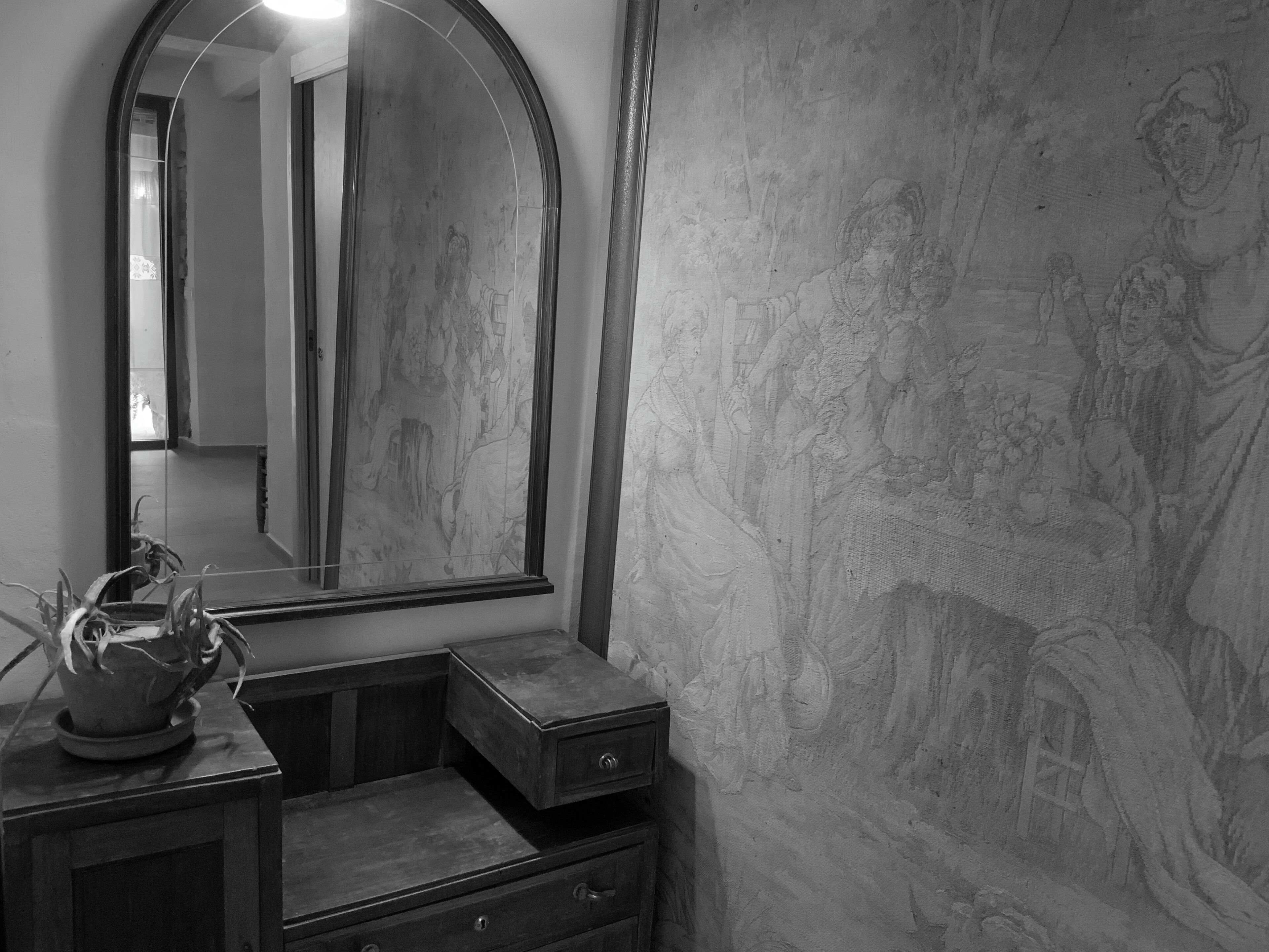 A bathroom with a large mirror, a sink, and a decorative wall.