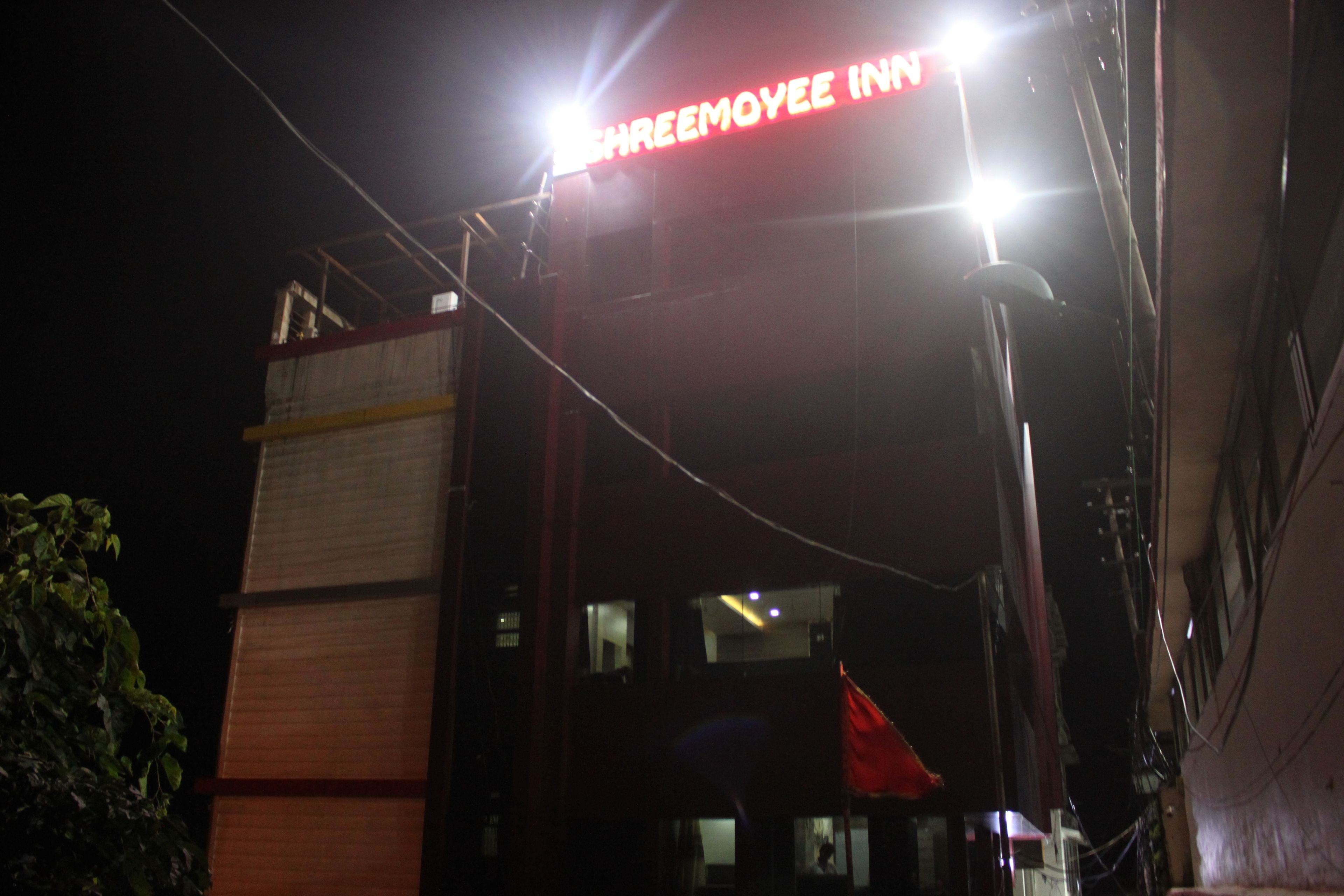 Un edificio con un letrero que dice "SHREEMOYEE INN" de noche.