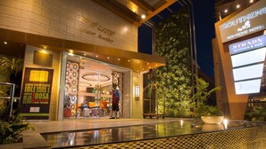 Entrada de hotel com design moderno, um restaurante visível chamado 'STRADA KITCHEN & BAR' e uma placa do 'SOUTHENNI BOUTIQUE HOTEL'.