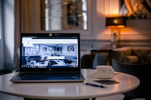 A laptop on a table displaying a webpage titled "Amber Design Residence."