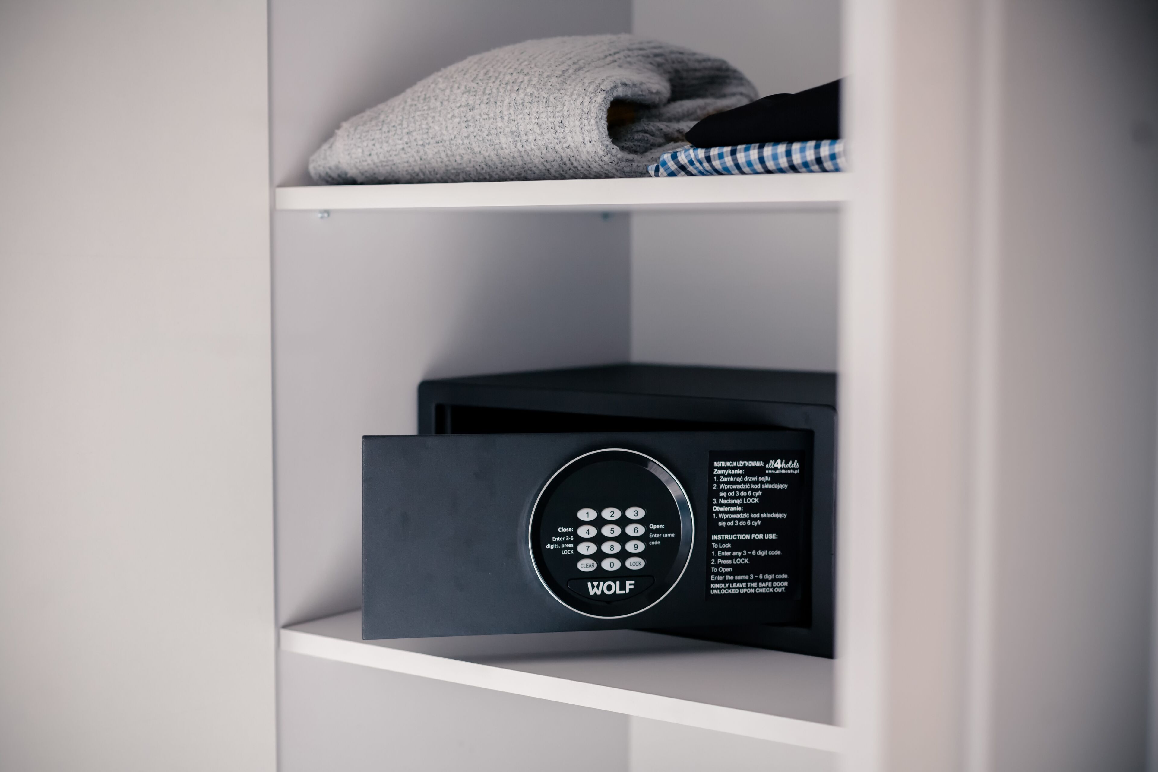 Una habitación moderna y minimalista con una caja fuerte empotrada y una toalla doblada cuidadosamente en el estante.