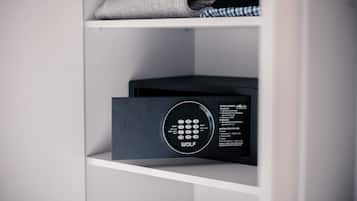 Una habitación moderna y minimalista con una caja fuerte empotrada y una toalla doblada cuidadosamente en el estante.