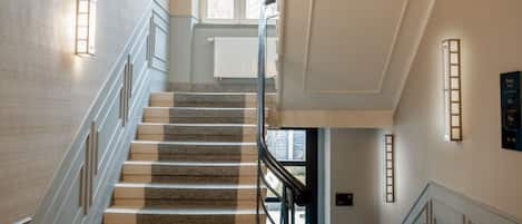 A grand staircase with a handrail, leading to an upper floor.
