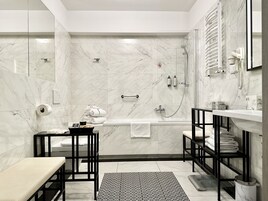A modern bathroom with a bathtub, shower, and toilet.