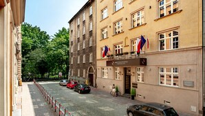 A building with multiple windows, a sign for 'Amber Design Residence', and flags on the balcony. - Amber Design Residence (Kraków)