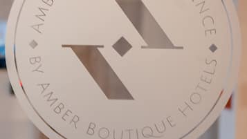A circular sign with the text "AMBER DESIGN RESIDENCE BY AMBER BOUTIQUE HOTELS".