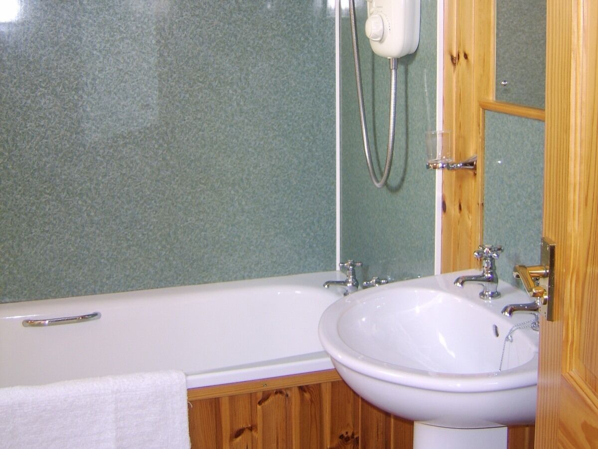 Un baño con bañera, lavabo y ducha.