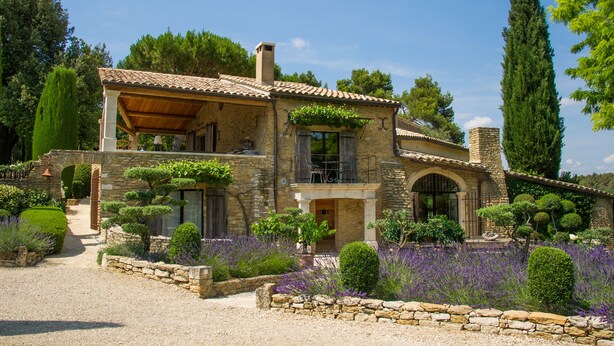 A stone house with a tiled roof, a balcony, and a garden with lavender. - Domaine Les Roullets (Oppede)