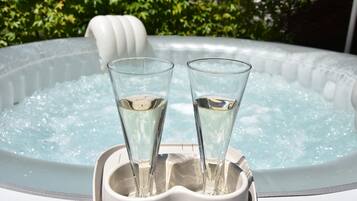 Dos vasos de agua en una bañera blanca con revestimiento blanco y superficie texturizada.