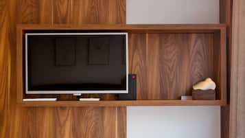 A modern room with a built-in TV, wooden paneling, and a ceiling-mounted air conditioner.