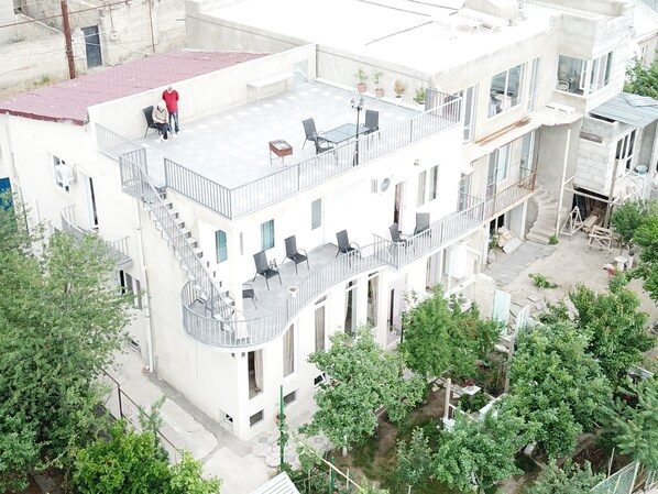 A multi-story building with balconies, outdoor seating, and a garden area. - Upstairs Hotel Tbilisi (Tbilisi)