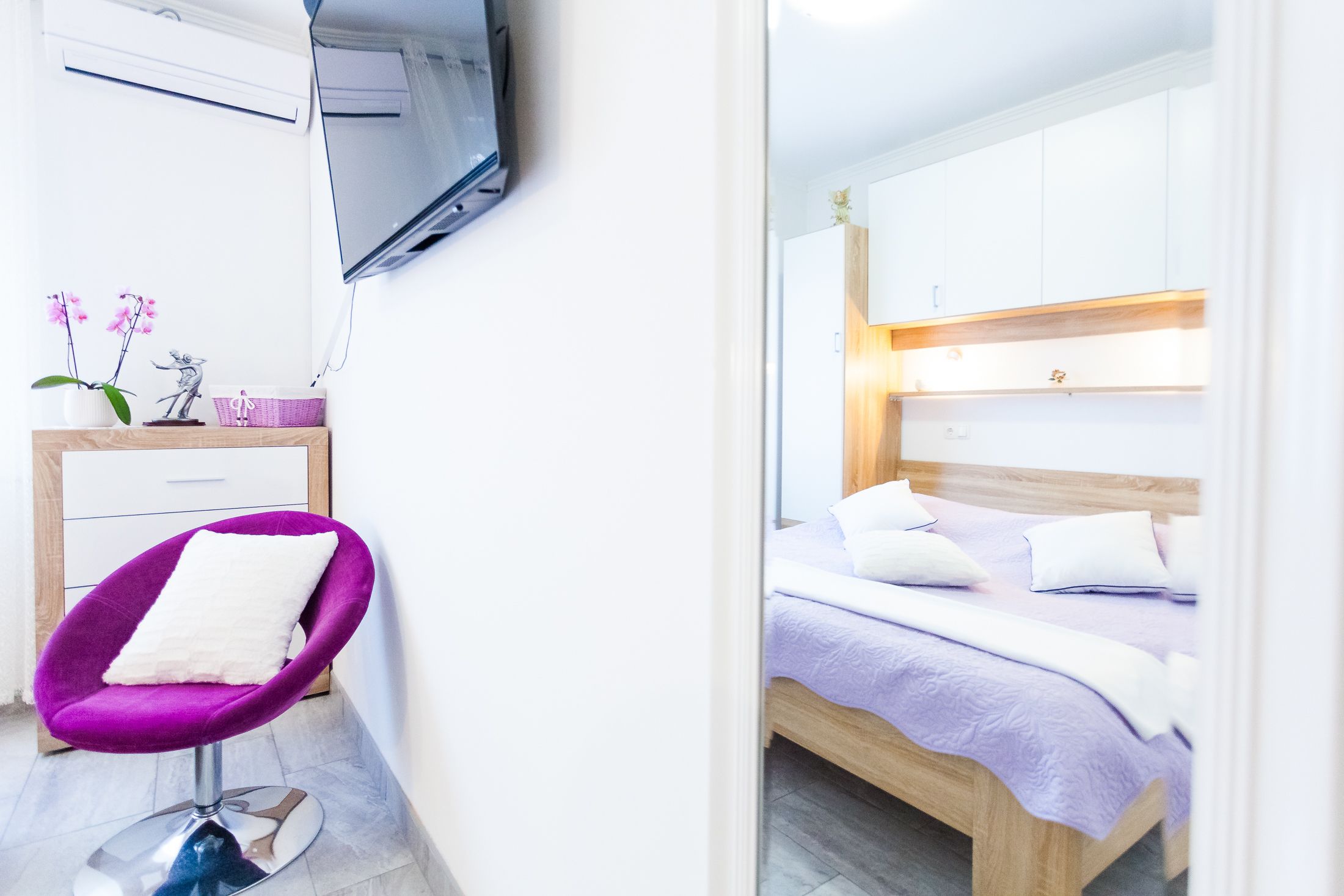 Un dormitorio moderno con una cama, un cabecero de madera y un escritorio pequeño con una silla.