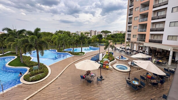 A resort with a swimming pool, outdoor seating, and a multi-story building. - Alta Vista Thermas Resort (Caldas Novas)