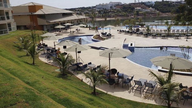 Un resort con un amplio espacio de piscina, mobiliario exterior y vistas del paisaje circundante.