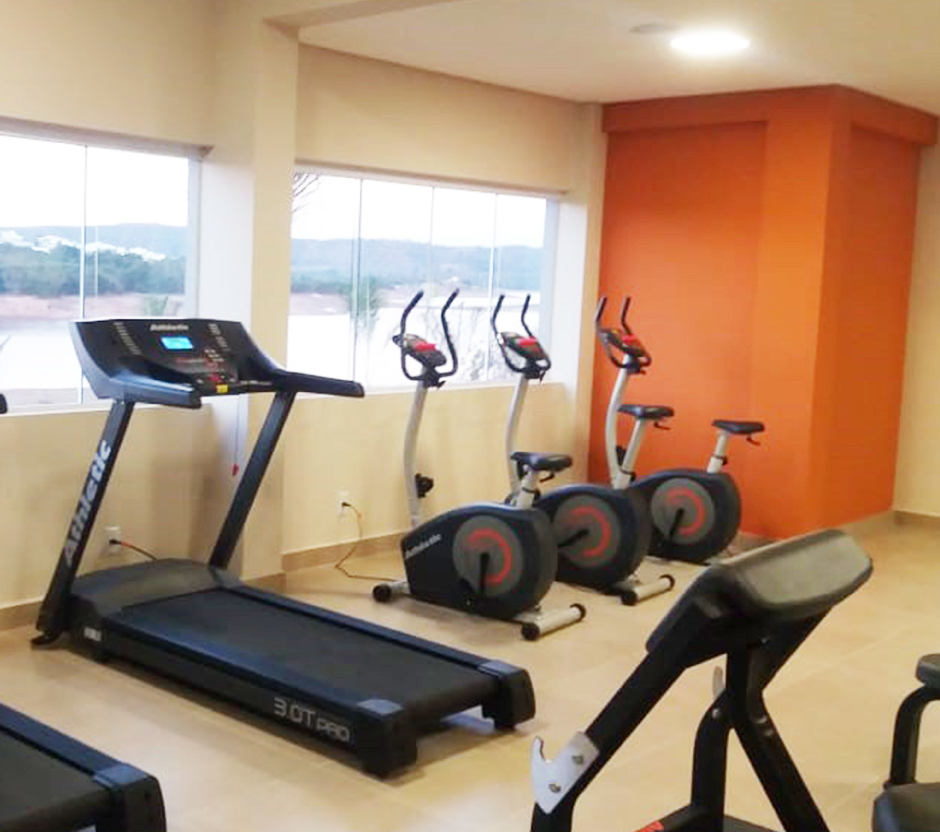 A gym with treadmills, stationary bikes, and a rowing machine.