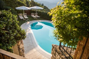 Una piscina al aire libre de temporada, sombrillas