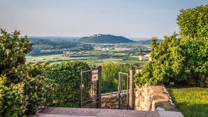 Una vista panorámica desde un portón que domina un valle, con una colina destacada en la distancia.