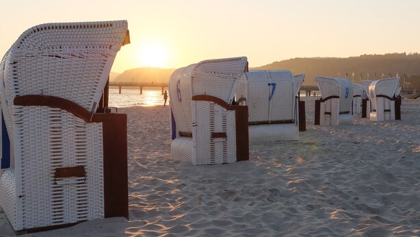 Beach chairs lined up on a sandy beach with a sunset in the background. - Appartementhaus Gutenberg - Für Paare, Freundinnen & Freunde, Alleinreisende - Parkplatz & WLAN - 2 Min zum See, 6 Min zum Strand (Binz)