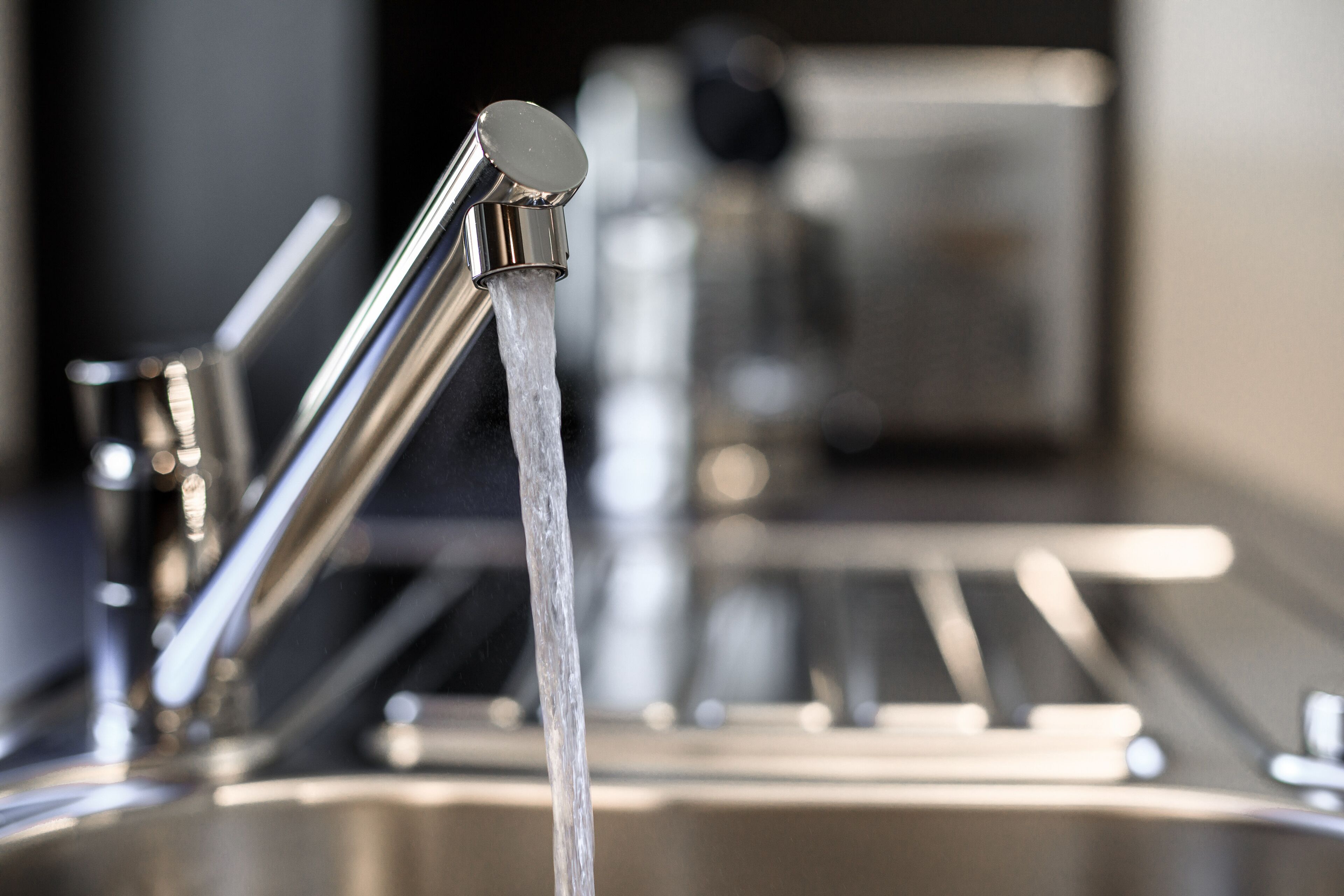 Une cuisine moderne dotée d’appareils électroménagers en acier inoxydable et d’un évier avec eau courante.