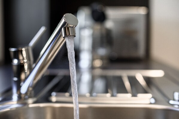Une cuisine moderne dotée d’appareils électroménagers en acier inoxydable et d’un évier avec eau courante.