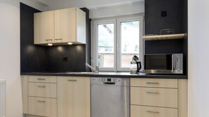 Una cocina moderna con lavavajillas, microondas y armarios de madera.