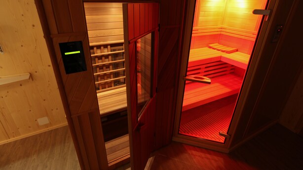 Una sauna con paredes de madera y un banco en el interior.