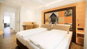 Una habitación de hotel con una cama grande, un cabecero de madera, un reloj en la pared y un pequeño escritorio con una lámpara.