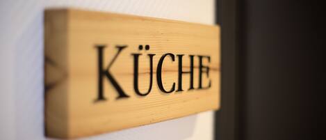 A wooden sign with the word "KÜCHE" on it.