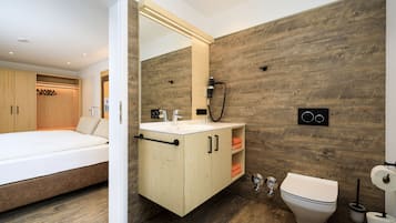 Un baño moderno con pared de madera, un lavabo blanco y un inodoro.